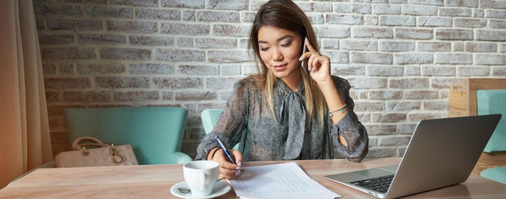 photo-young-woman-talking-on-mobile-at-desk